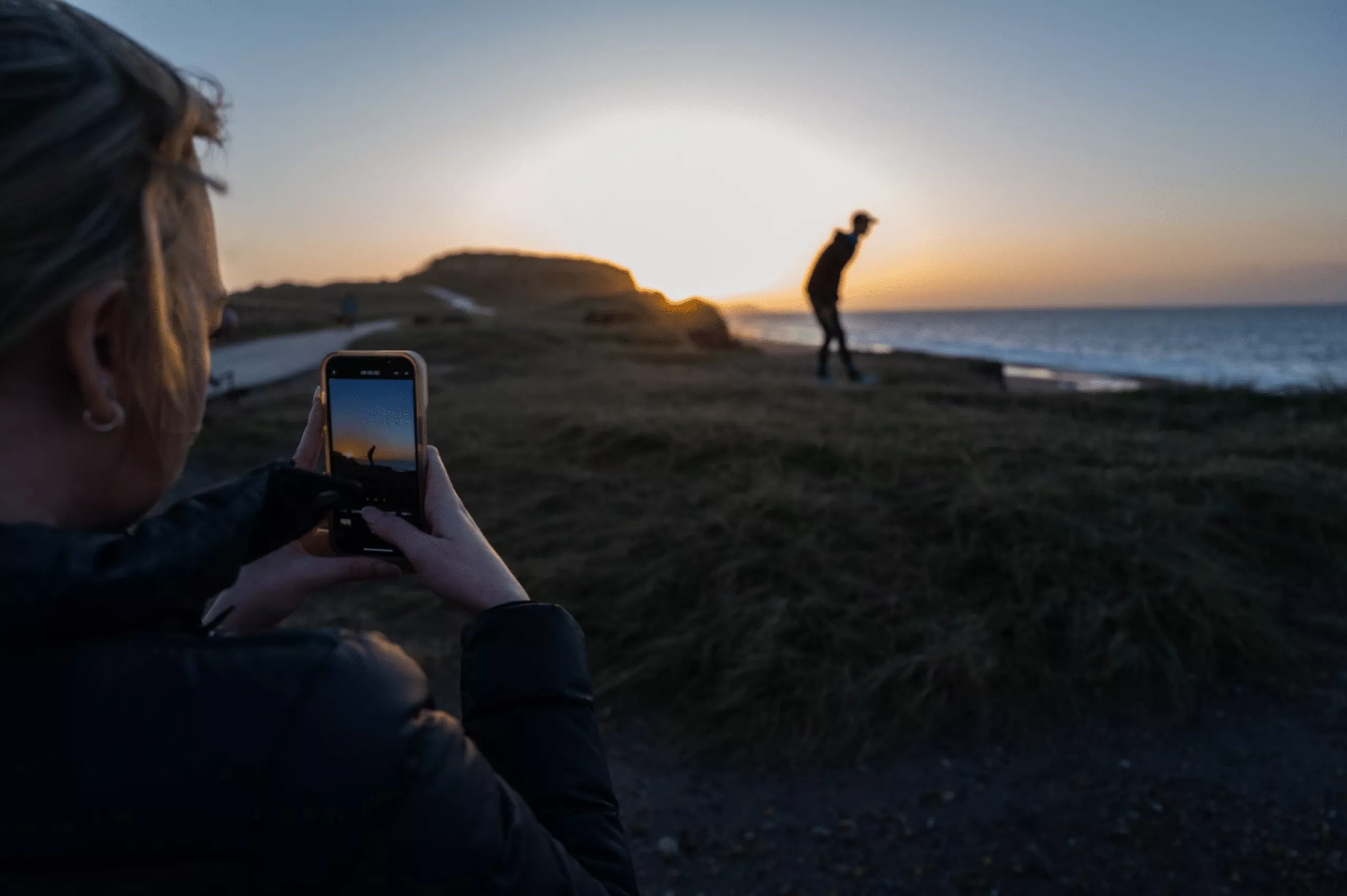 taking photo of man on cliff